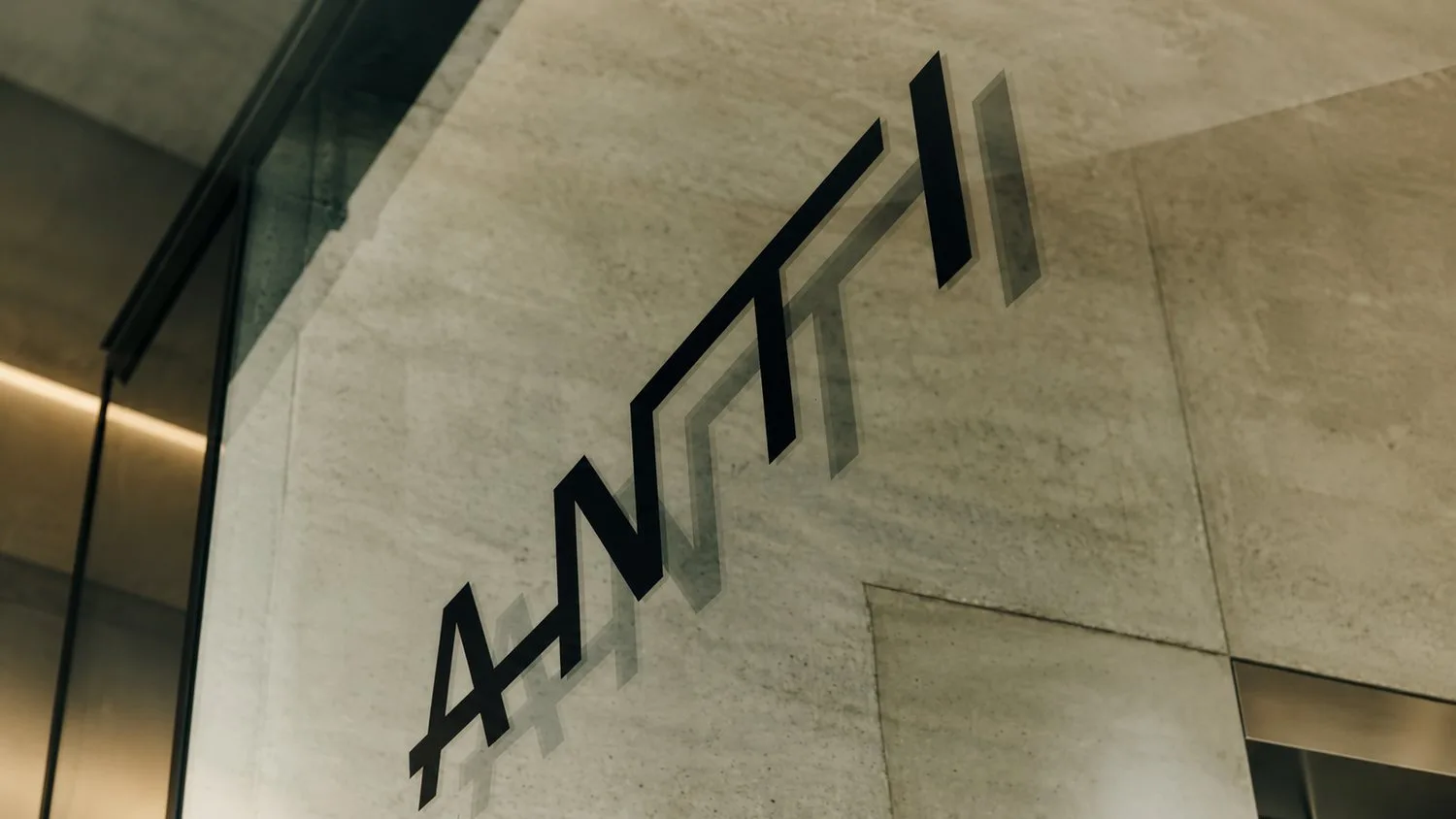The ANTI wordmark etched on glass against a concrete wall